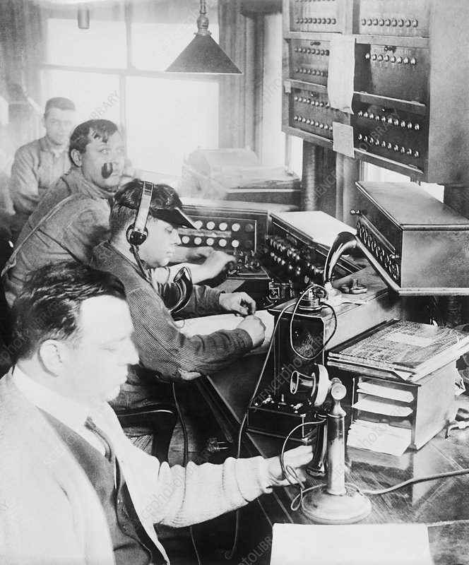 Telecommunications operators. Men operating radio and telephone equipment, including control panels, headphones, Morse keys, and telephone speakers and receivers. Telegraphy and Morse code was developed in the 1830s and 1840s, telephone technology in the 1870s, and radio technology in the 1890s. This photograph, from the period between 1921 and 1922, is from the National Photo Company Collection, consisting mostly of photographs taken in Washington DC, USA.